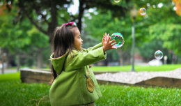 an image of a child playing with soap bubbles